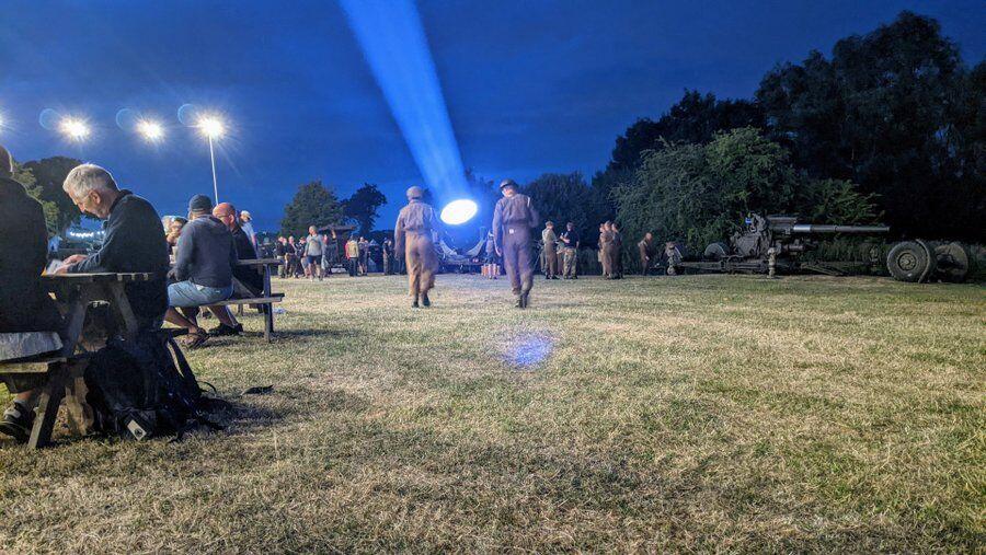 Two soldiers walk towards a searchlight at We Have Ways Fest