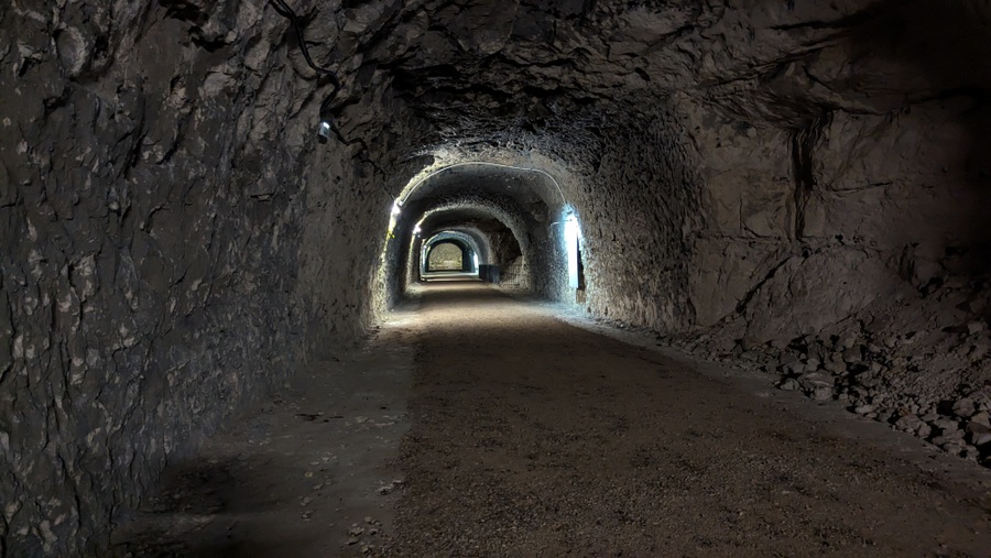 A large rough hewn tunnel with a gravel floor. Wide enough to take vehicles.